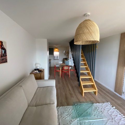 Verrière atelier Vue d'un intérieur moderne avec un mur vitré et un canapé en cuir.