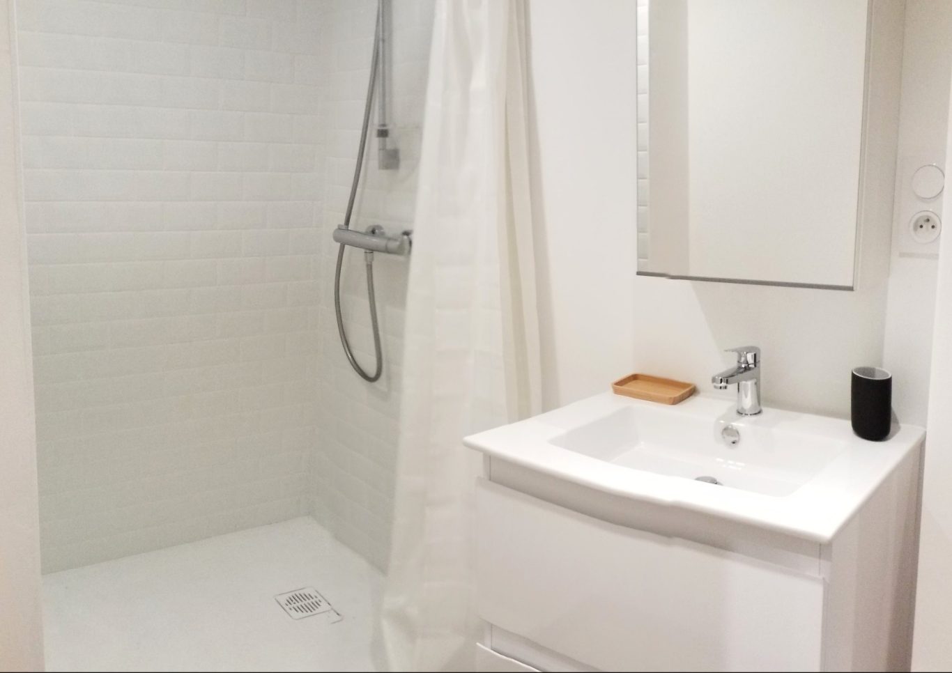 Rénovation d'une salle de bain Salle de bain moderne avec douche, lavabo et miroir. Dominante blanche et minimaliste.