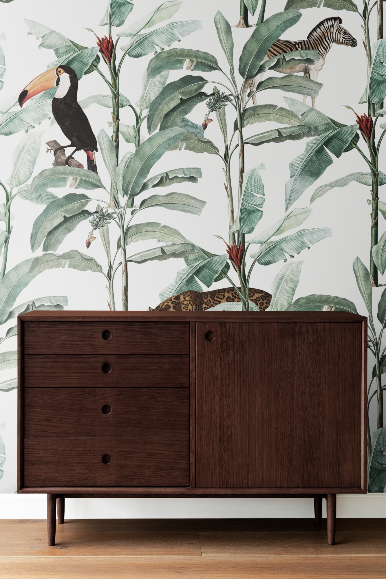 QUELLE VUE SUR VOTRE PROCHAIN PROJET DECO Mobilier en bois foncé devant un papier peint tropical avec toucans et feuillage.
