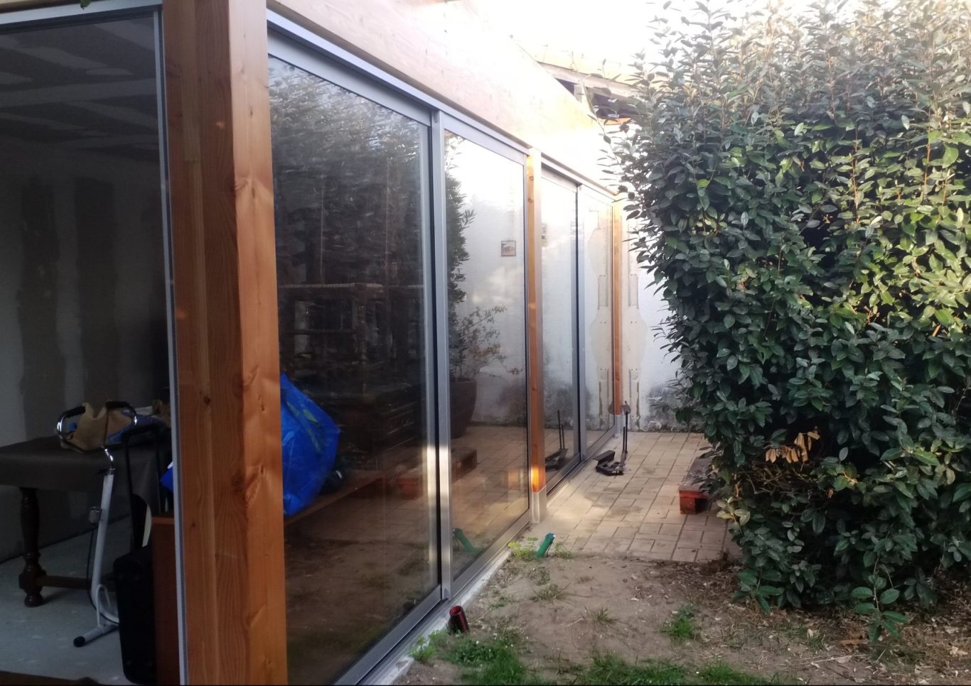 Construction d'une véranda Rénovation d'une véranda lumineuse avec des baies vitrées et un jardin verdoyant.