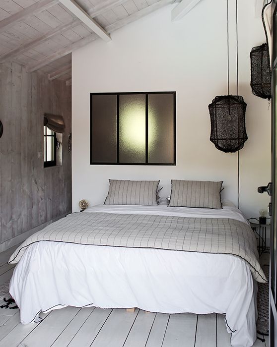 TRANSFORMER UN GARAGE EN CHAMBRE Chambre moderne avec un lit double, draps gris et décor minimaliste.